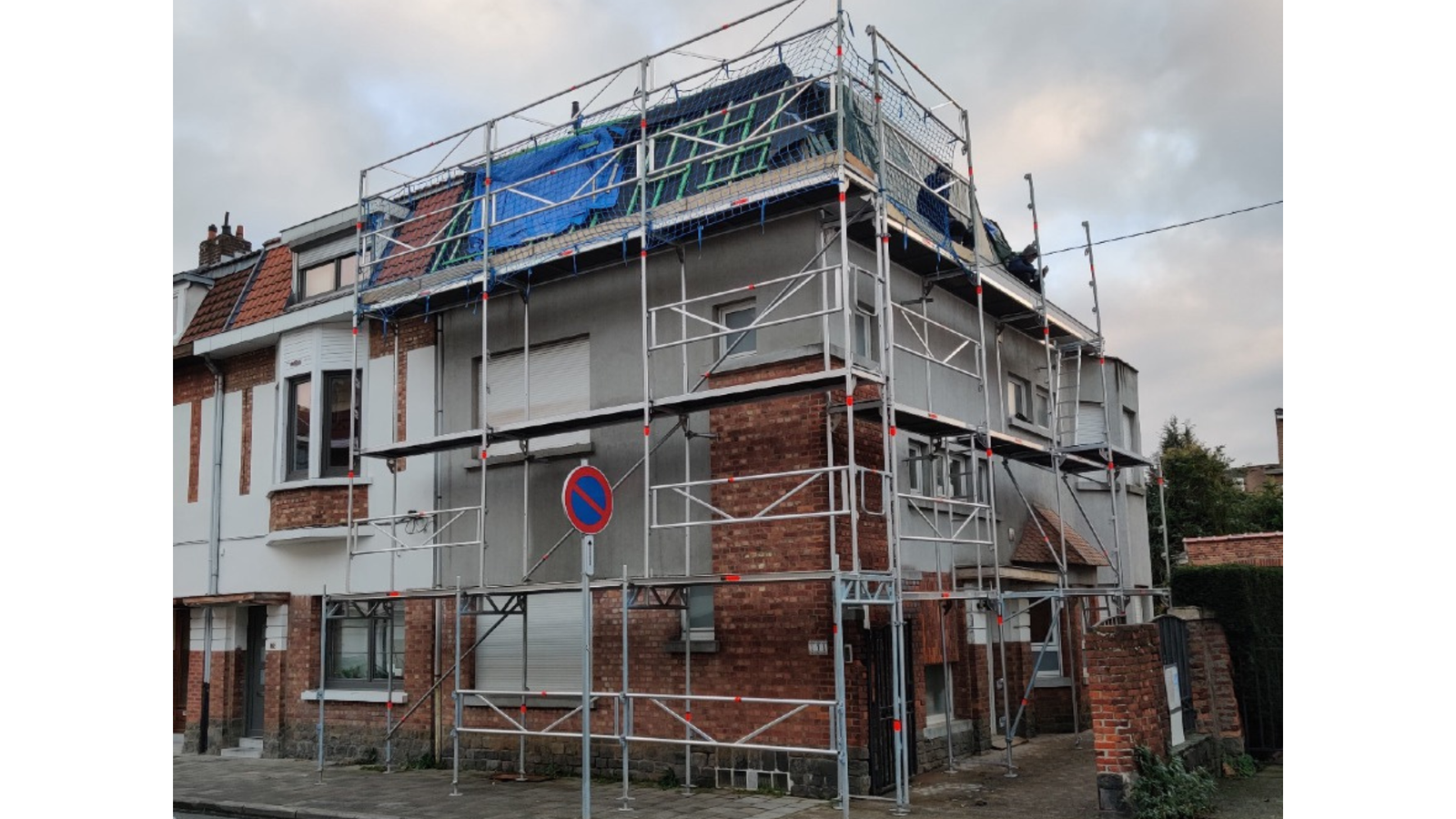 Photo de la façade avant rénovation avec échafaudage installé à Evere par La Compagnie des Bâtisseurs